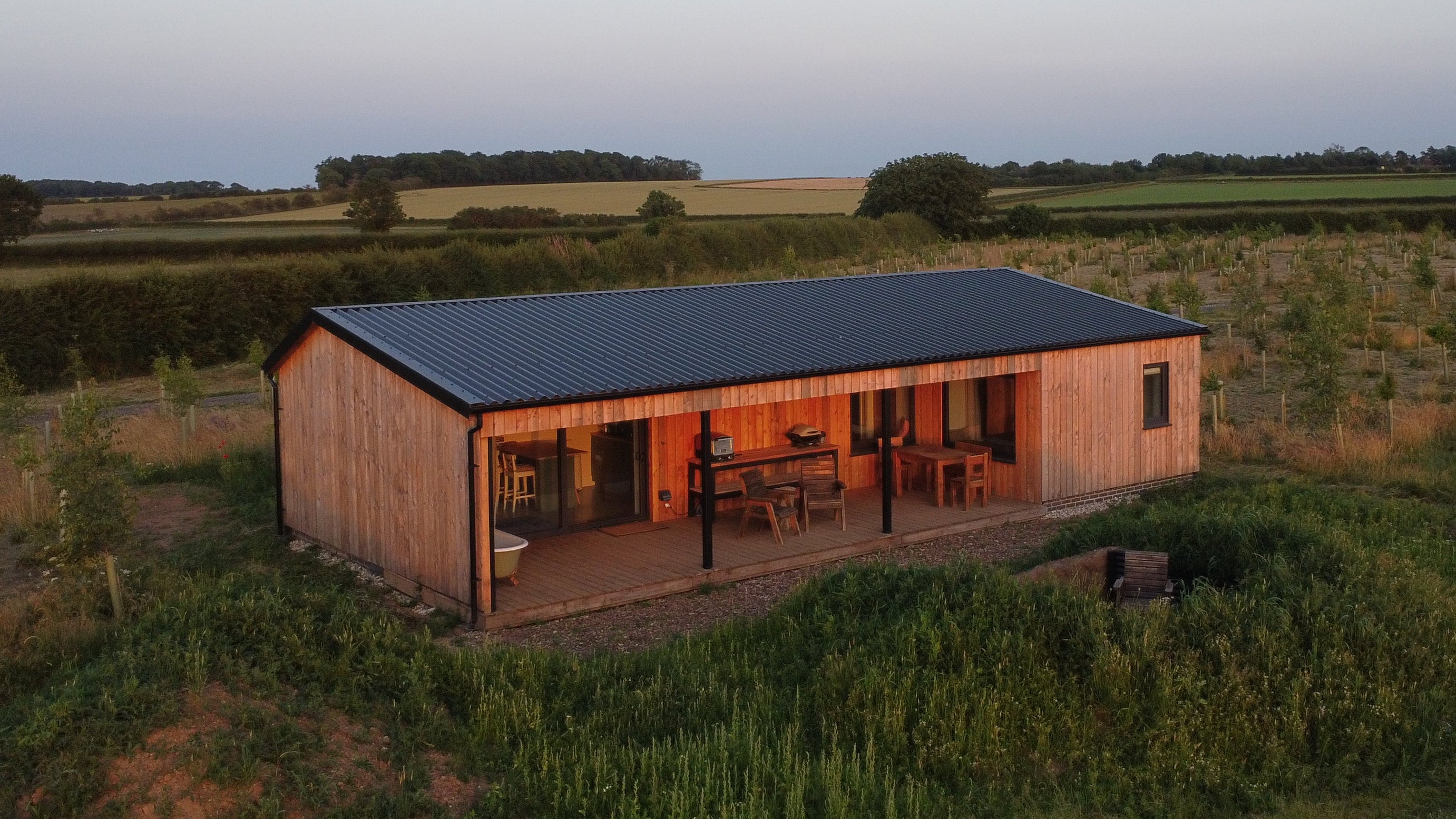 Wooden cabin with a black roof in a rural landscape